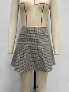 High waist A-line plaid skirt with gold buttons and ruffle hem on a tailor mannequin