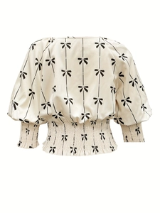 Détail de la taille élastiquée et de l'imprimé nœuds sur cette blouse blanche
