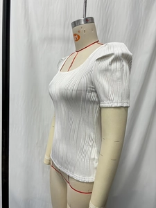 Detail view of white ribbed plisse fabric with vertical texture on a slim square neck top