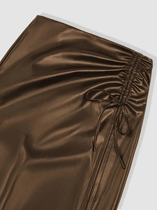 Detail view of brown PU leather skirt with ruched side drawstring and bowknot tie