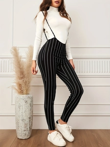 Detailed view of black and white vertical striped overalls with thin shoulder straps