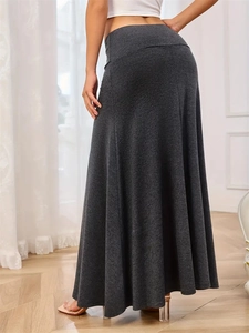 Detail view of the back of a charcoal grey knitted maxi skirt with a flared A-line silhouette