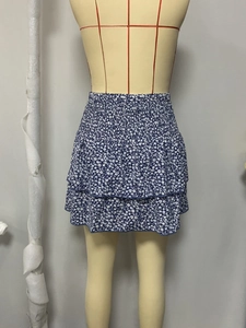Dettaglio di minigonna blu navy a fiori con vita alta elastica e balze a strati