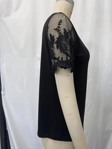 Detailed view of elegant black short sleeve top with delicate lace floral mesh sleeves