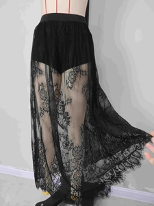 Detailed close-up of gothic black floral lace fabric with delicate eyelash trim edges