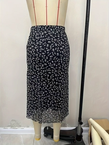 Detailed view of black floral midi skirt with high waist design and elastic frill hemline