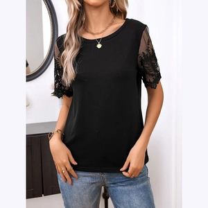 Detail of elegant black knit t-shirt featuring intricate lace embroidery on the sleeves
