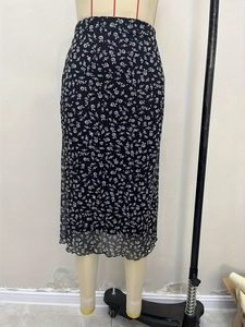 Detail of floral high waist midi skirt showing delicate lettuce edge hem and daisy print