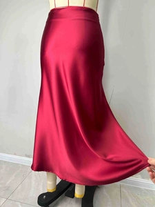 Detailed view of dark red satin A-line midi skirt with high gloss and smooth drape