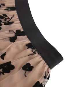 Elegant floral flocked mesh skirt featuring a black elastic waistband and airy A-line silhouette