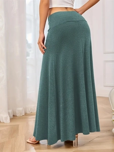 Detail shot of a forest green high waist A-line knit maxi skirt with rich fabric texture
