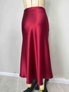 Detail showing the smooth texture and elegant drape of the wine red satin midi skirt