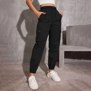 Detail of high waist drawstring elastic waistband and flap cargo pockets on black joggers
