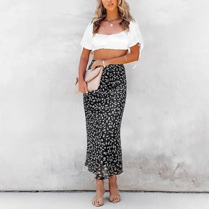 Detail of high waisted floral midi skirt with side slit and white puff sleeve top