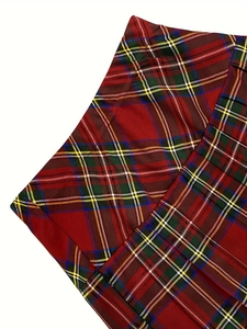 Detailed macro view of red pleated plaid skirt fabric showing twill weave texture
