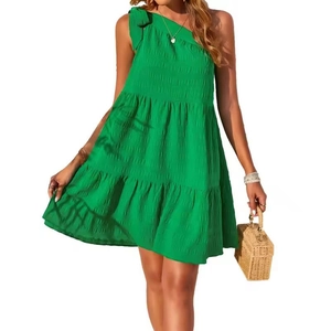 Close-up of vibrant green one-shoulder dress with bow tie and shirred bodice detail