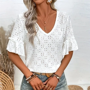 Close-up of intricate hollow floral embroidery and tiered ruffle sleeves on white V-neck top
