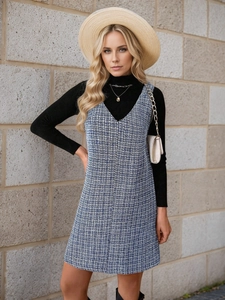 Detail of blue and white tweed V-neck pinafore dress paired with a black turtleneck