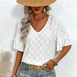 Detail of white V-neck knit top showing intricate hollow embroidery and ruffled cuffs