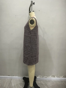 Detailed texture of sleeveless houndstooth tweed dress in red, black and white tones