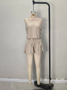 Detail of beige two-piece set featuring a buttoned sleeveless top and belted shorts