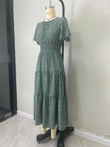 Dettaglio di un abito lungo a fiori verde scuro con gonna a balze e vita elastica