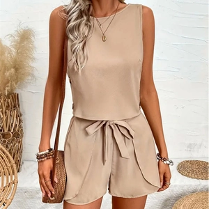 Detail of beige sleeveless top and belted shorts featuring unique curved hemline