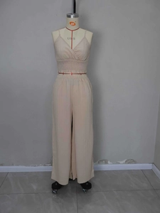 Detail of cream smocked camisole and high-waisted wide-leg trousers with pleated texture