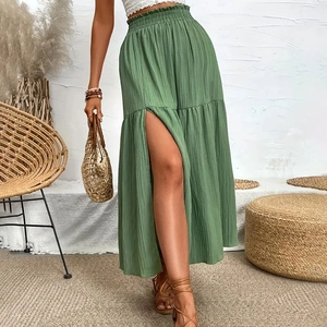 Detail view of high waist elastic green pleated maxi skirt with a stylish side slit design