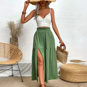 Detail of smocked waist on a grass green high-slit maxi skirt with ruffle hem detail