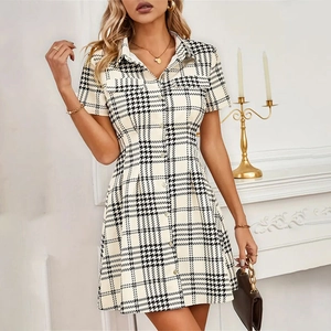 Detail of a houndstooth shirt dress featuring a turn-down collar and single-breasted buttons