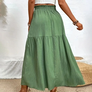 Detail of green high-waist tiered maxi skirt featuring elastic smocked waist and ruffles
