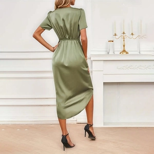 Detail view of the back of a light green satin midi dress with irregular hem and elastic waist