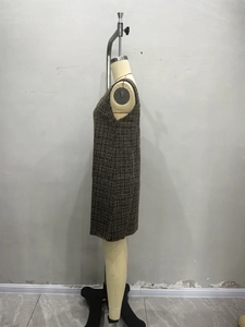 Detailed texture of sleeveless tweed dress in dark coffee and gold woven fabric