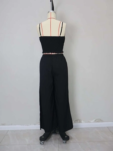 Detail view of black jacquard stripe crop top and high-waisted split leg trousers set