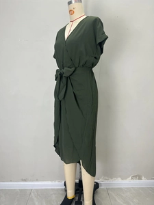 Detail view of deep green wrap dress showing V-neckline and waist tie bow detail