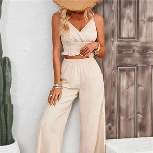 Detail of smocked beige tank top and wide-leg trousers with textured summer fabric