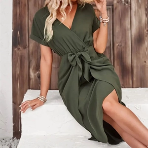 Detailed view of dark green short-sleeved V-neck dress with tied waist bow and split hem