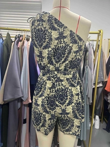 Detail des Blumendrucks auf beigem One-Shoulder-Jumpsuit mit Kordelzug an der Taille