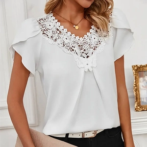 Détail du col en V avec broderie en dentelle délicate sur une blouse en mousseline blanche