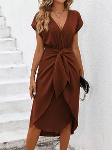 Detail of caramel V-neck wrap dress with side slit and waist tie knot styling