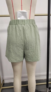 Detail view of the elastic high waist and textured green fabric on the back of shorts