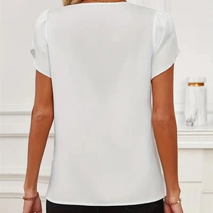 Détail du chemisier blanc à manches bouffantes en mousseline avec un élégant drapé au dos