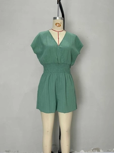 Macro detail of vintage green vertical striped romper featuring a V-neck and elastic waist