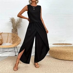 Détail du haut noir sans manches et pantalon large portefeuille plissé