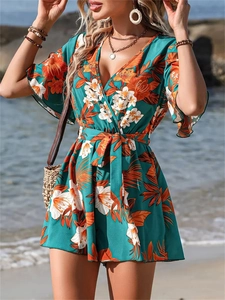Détail de la barboteuse florale tropicale avec col en V, manches volantées et style plage