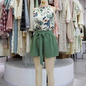 Detailed view of floral halter top and green shorts with a tied bow belt set