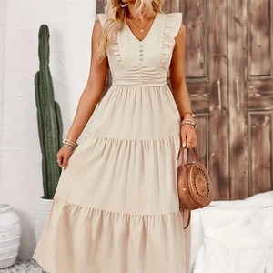 Detailed view of beige tiered maxi dress with ruffled shoulders and decorative front buttons