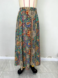 Détail de la jupe longue à taille haute avec imprimés paisley vibrants et fente latérale