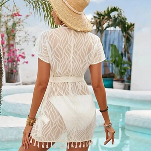Back view of white lace beach cover-up with wavy texture, waist tie and fringe hem details